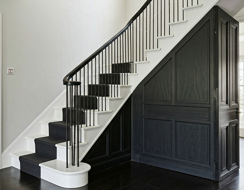 black bannister and white staircase with black carpet runner